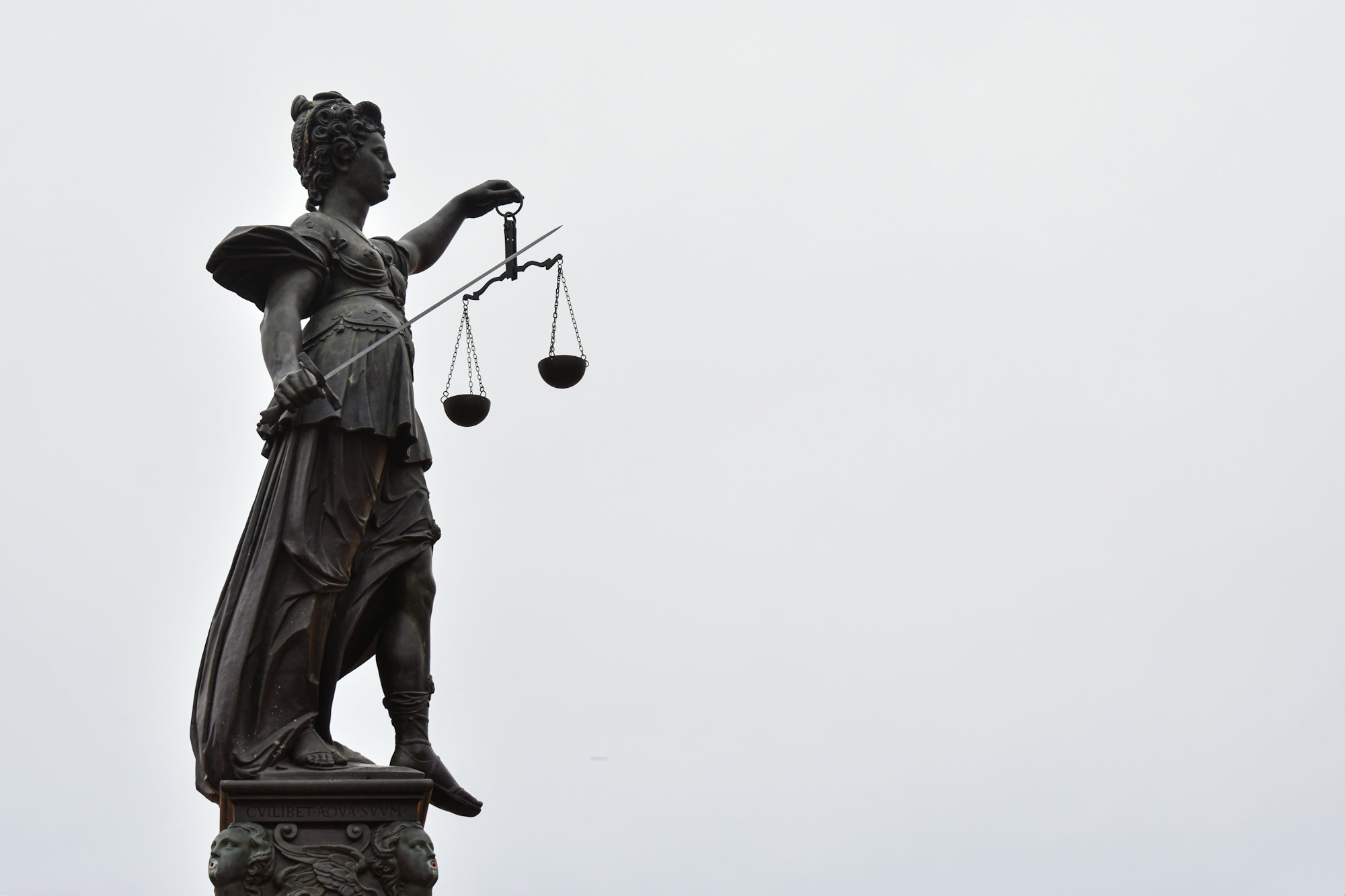a-statue-of-lady-justice-holding-a-scale-of-justice.jpg A statue of lady justice holding a scale of justice